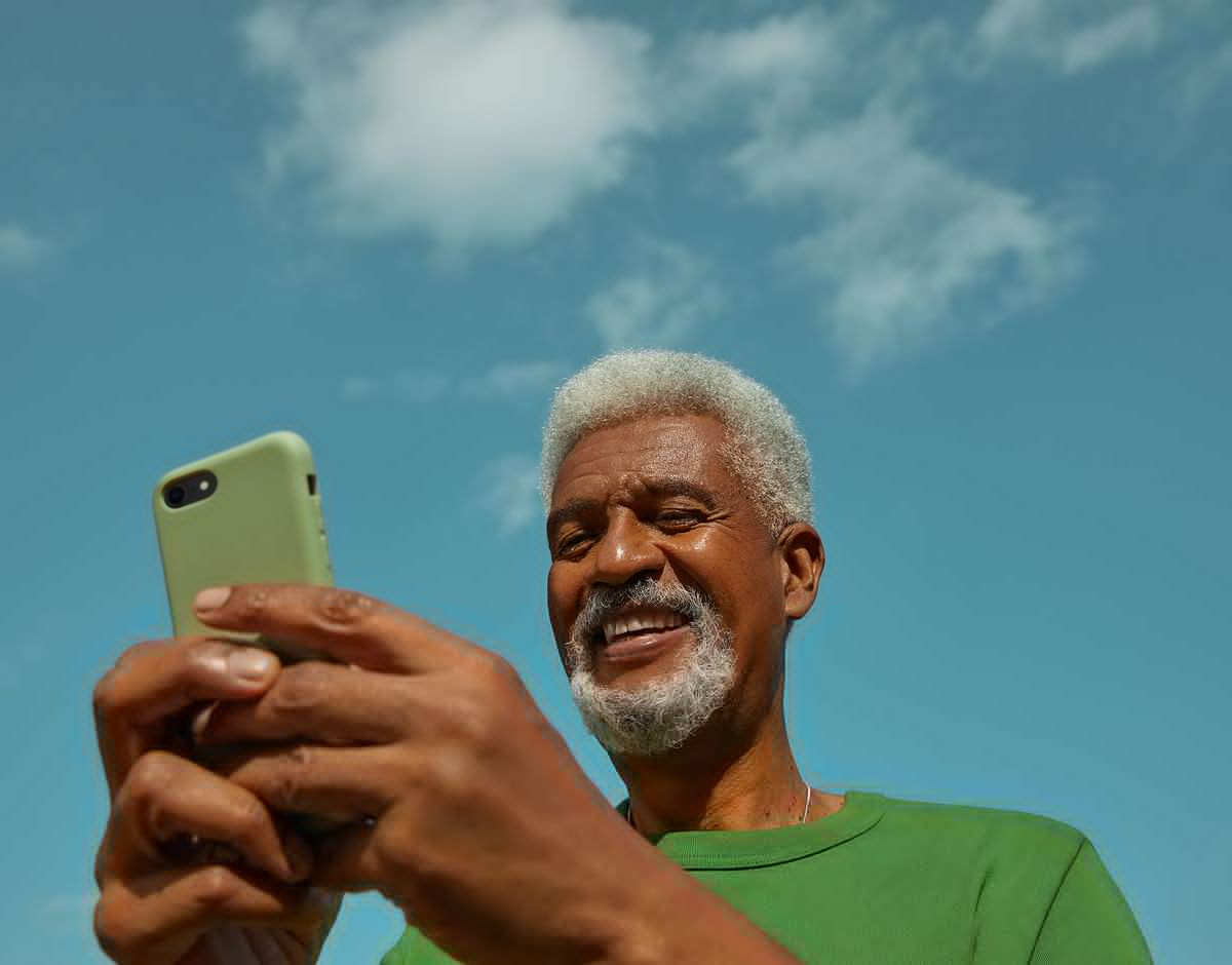 Man smiling while looking at his phone